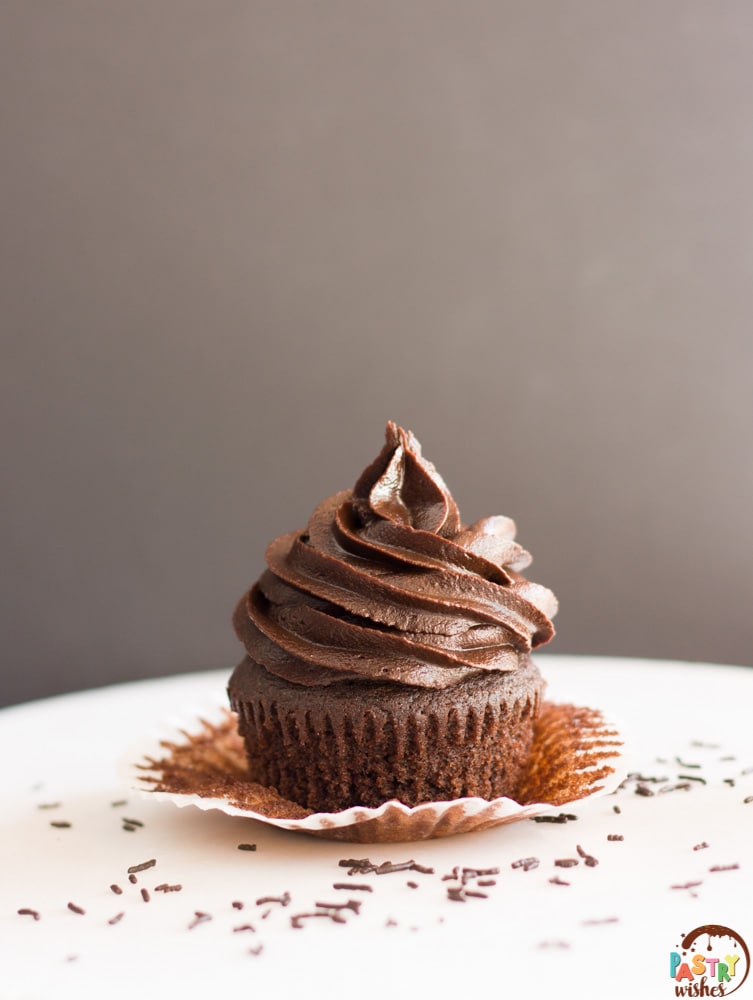 unwrapped chocolate cupcake with dark chocolate frosting and chocolate sprinkles