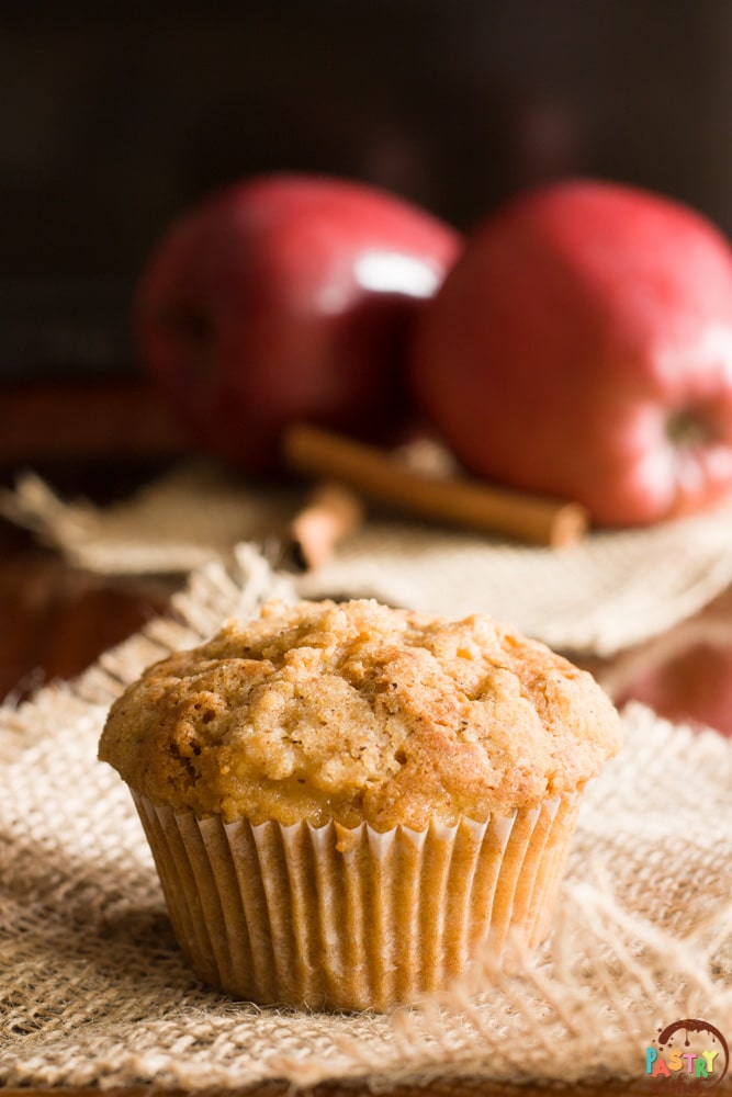streusel top apple muffin with 2 apples and 2 cinnamon sticks