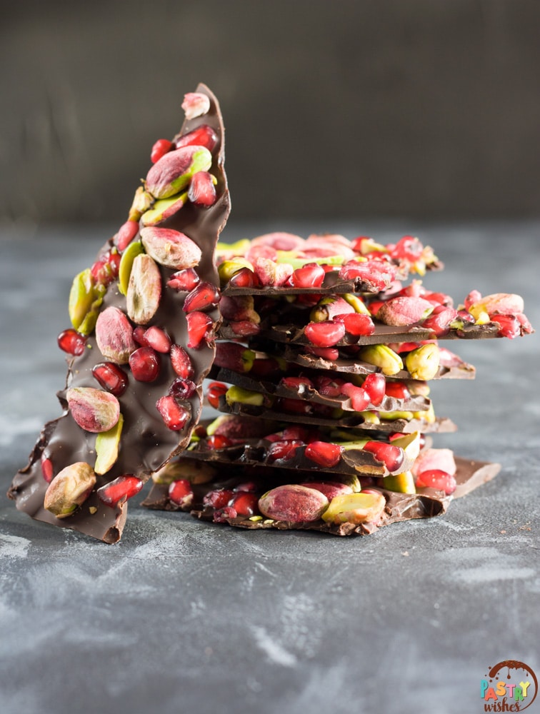 chocolate pomegrante pistachio bark pieces stacked in a pile