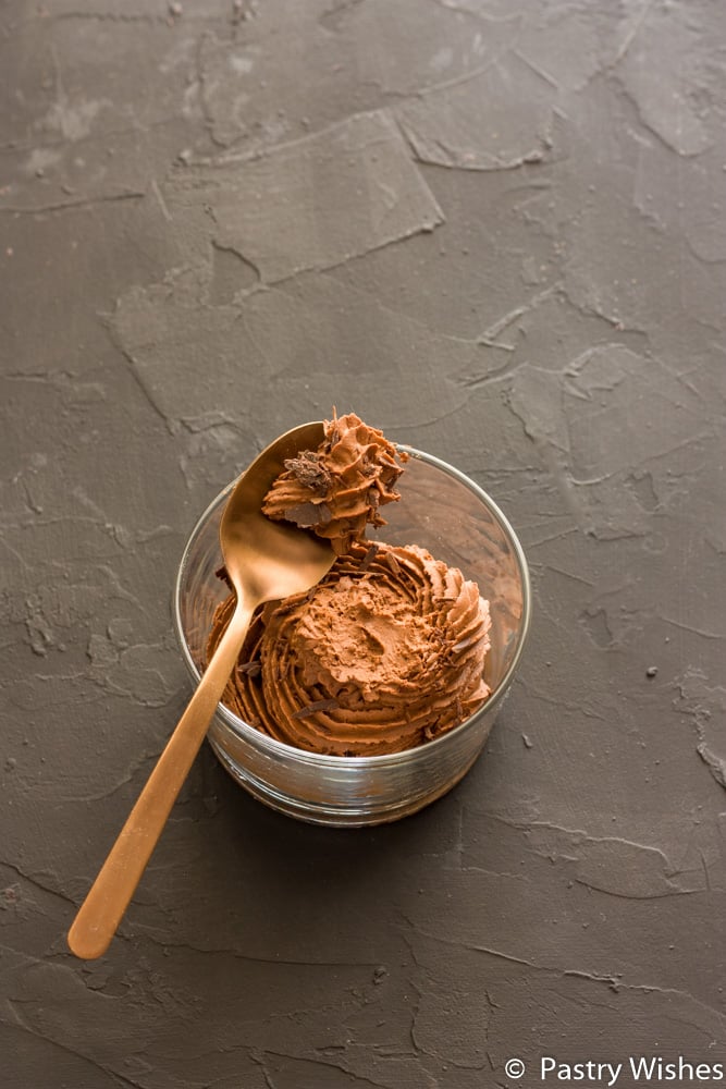 two ingredient chocolate mousse in a glass with a spoon on top on a dark surface