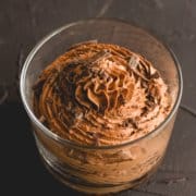two ingredient chocolate mousse in a glass with chocolate shavings on top on a dark surface