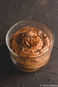two ingredient chocolate mousse in a glass with chocolate shavings on top on a dark surface