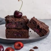 chocolate cherry brownies on a plate with a cherry on top