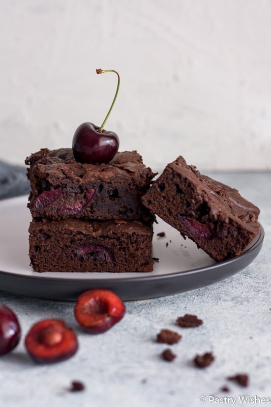 chocolate cherry brownies on a plate with a cherry on top
