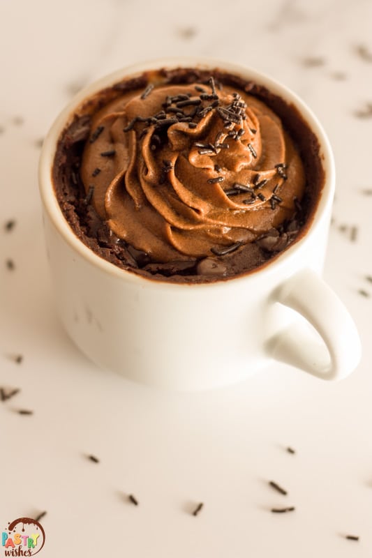 vegan mug brownie with chocolate buttercream frosting and chocolate sprinkles