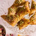 baklava triangles and dried roses on a plate
