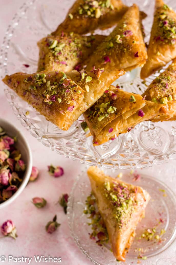 baklava triangles and dried roses on a plate