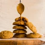 A stack of biscoff butter cookies with a spoon drizzling biscoff spread on top.