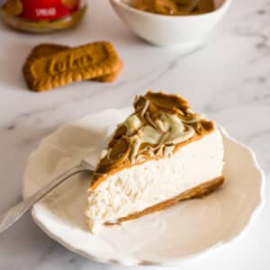A slice of biscoff cheesecake on a white plate.