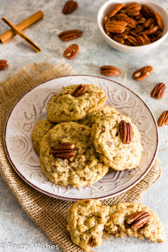 vegan pecan cookies on a plate with pecans in the background