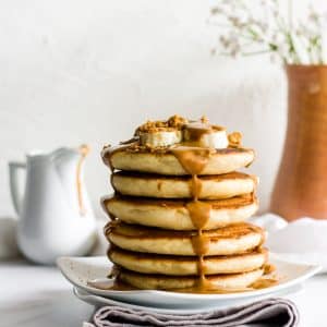 A stack of pancakes with melted biscoff spread and bananas.