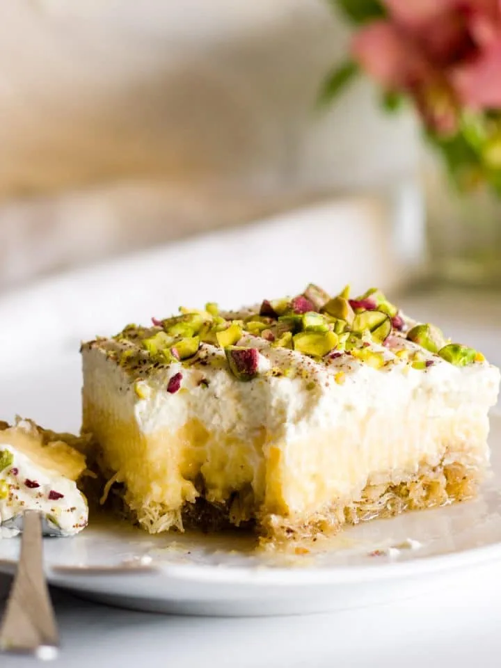 A slice of greek ekmek kataifi on a white plate.