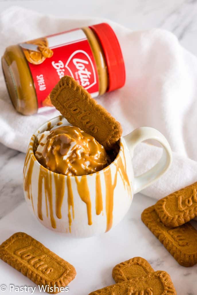 biscoff mug cake with whipped cream, melted biscoff spread and biscoff cookies