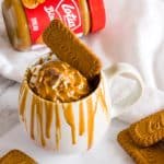 Biscoff mug cake with whipped cream, biscoff cookies and melted biscoff spread.