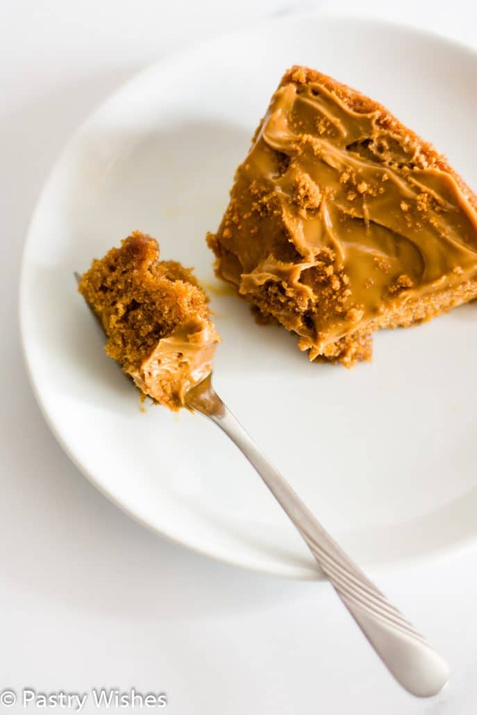 a slice of 3 ingredient biscoff cake on a white plate with a fork