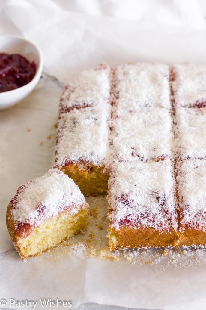 slices of coconut and jam cake with a bowl of jam in the background