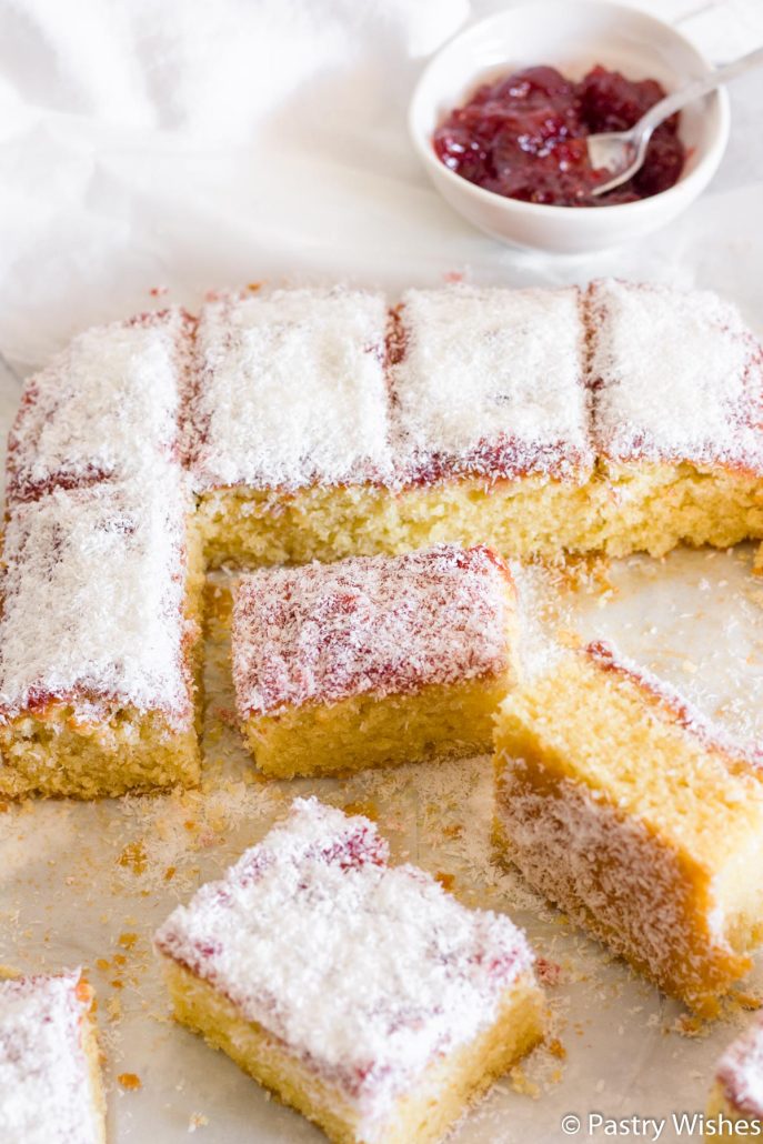 slices of coconut and jam cake with a bowl of jam in the background