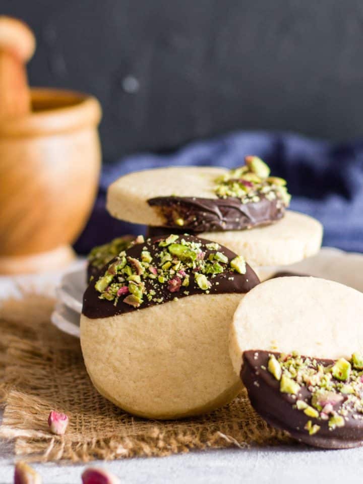 Chocolate dipped sugar cookies with chopped pistachios.
