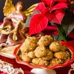Melomakarona greek Christmas honey cookies on a christmas plate surrounded by Christmas decorations.
