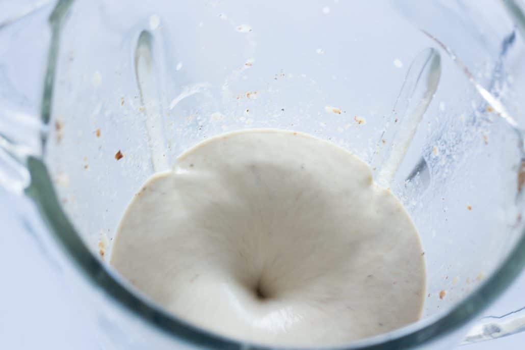 A blender blending ingredients for a granola smoothie.