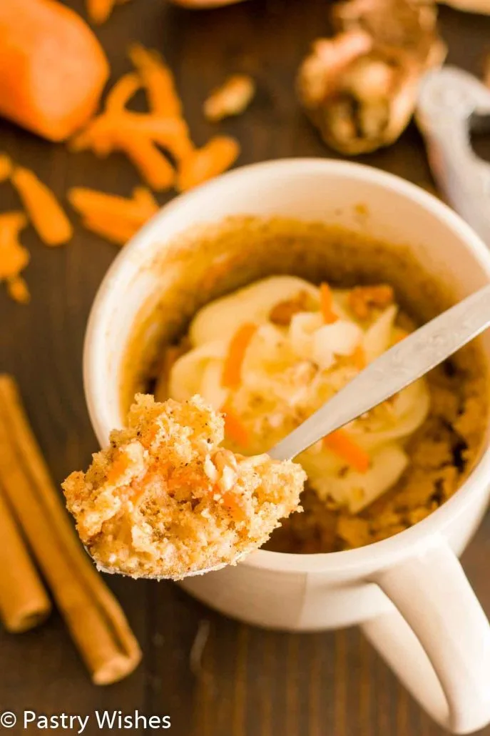 A close up of some carrot mug cake on a spoon.
