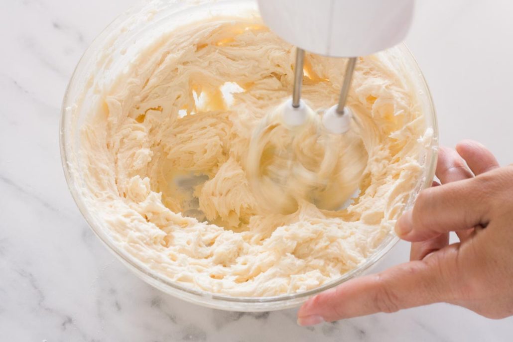 Mixing Earl Grey buttercream with a hand mixer.