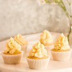 Earl Grey cupcakes on a marble platter with flowers in the background.