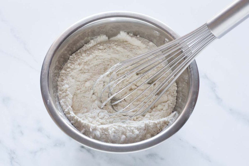 Whisking flour, baking powder and salt in a mixing bowl.