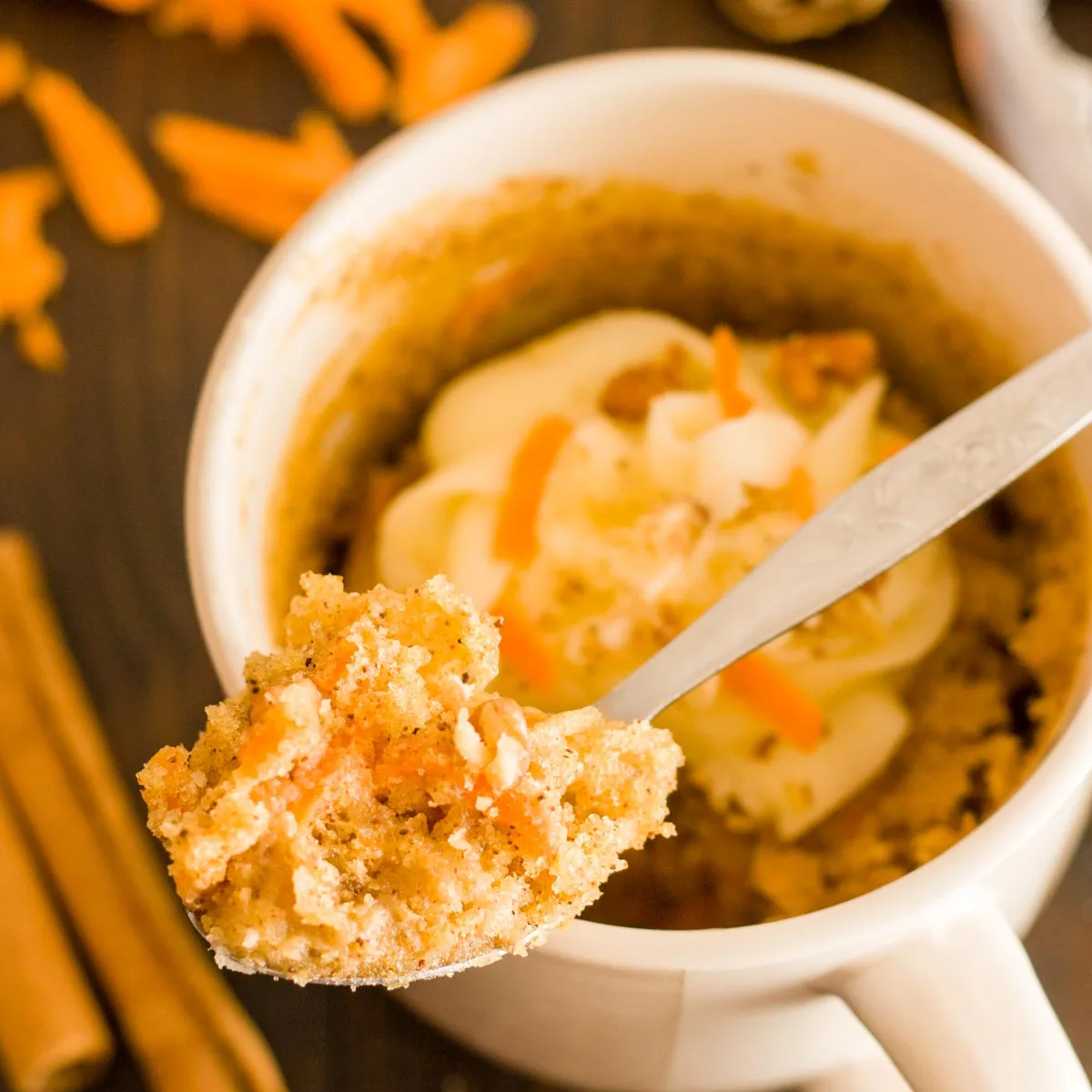 A close up of some carrot mug cake on a spoon.