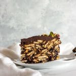 A slice of lazy cake on a white plate on a white surface.