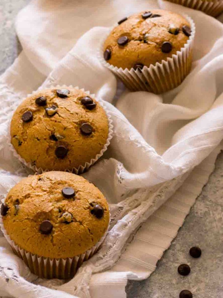 Vegan chocolate chip muffins on a white tablecloth.