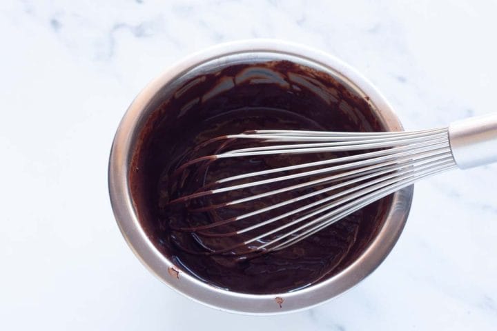Whisking cocoa powder and water in a small mixing bowl.