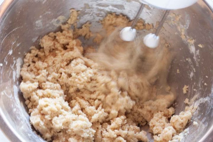 Beating oil and buttermilk with dry ingredients with a hand mixer.