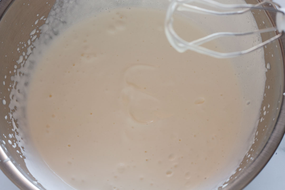 Beating heavy cream to soft peaks with a hand mixer.