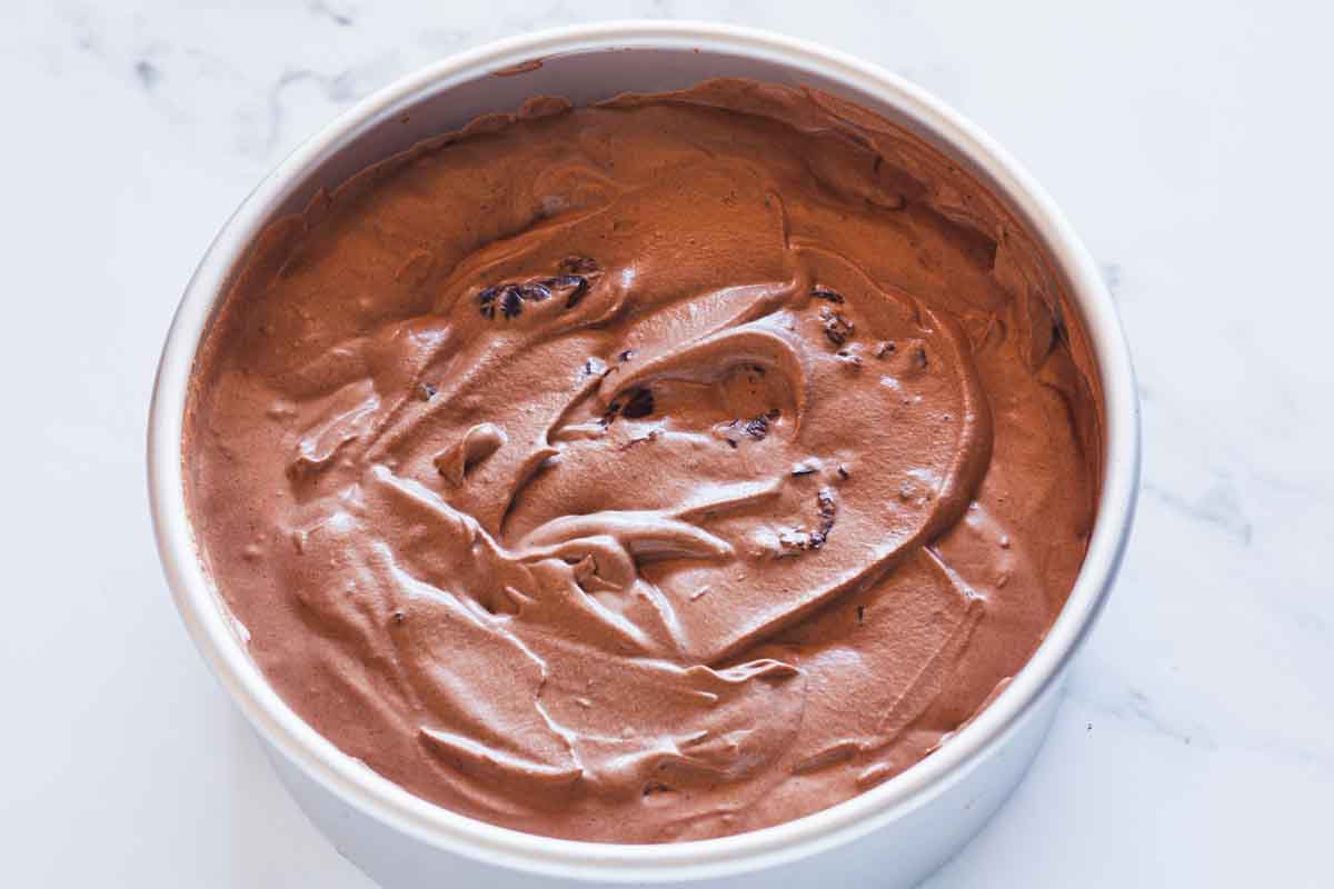 A metal cake pan filled with black forest ice cream mixture before freezing.