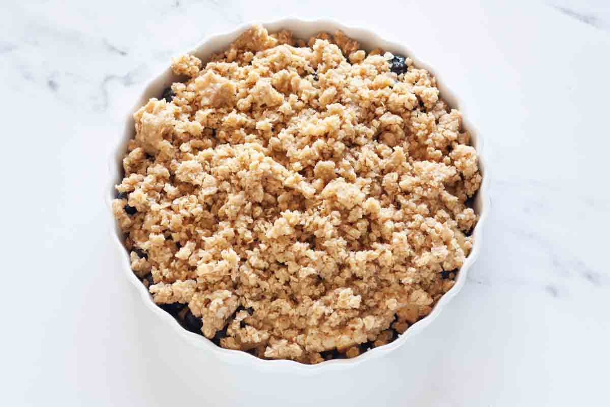 Crumble topping over blueberry apple mixture.