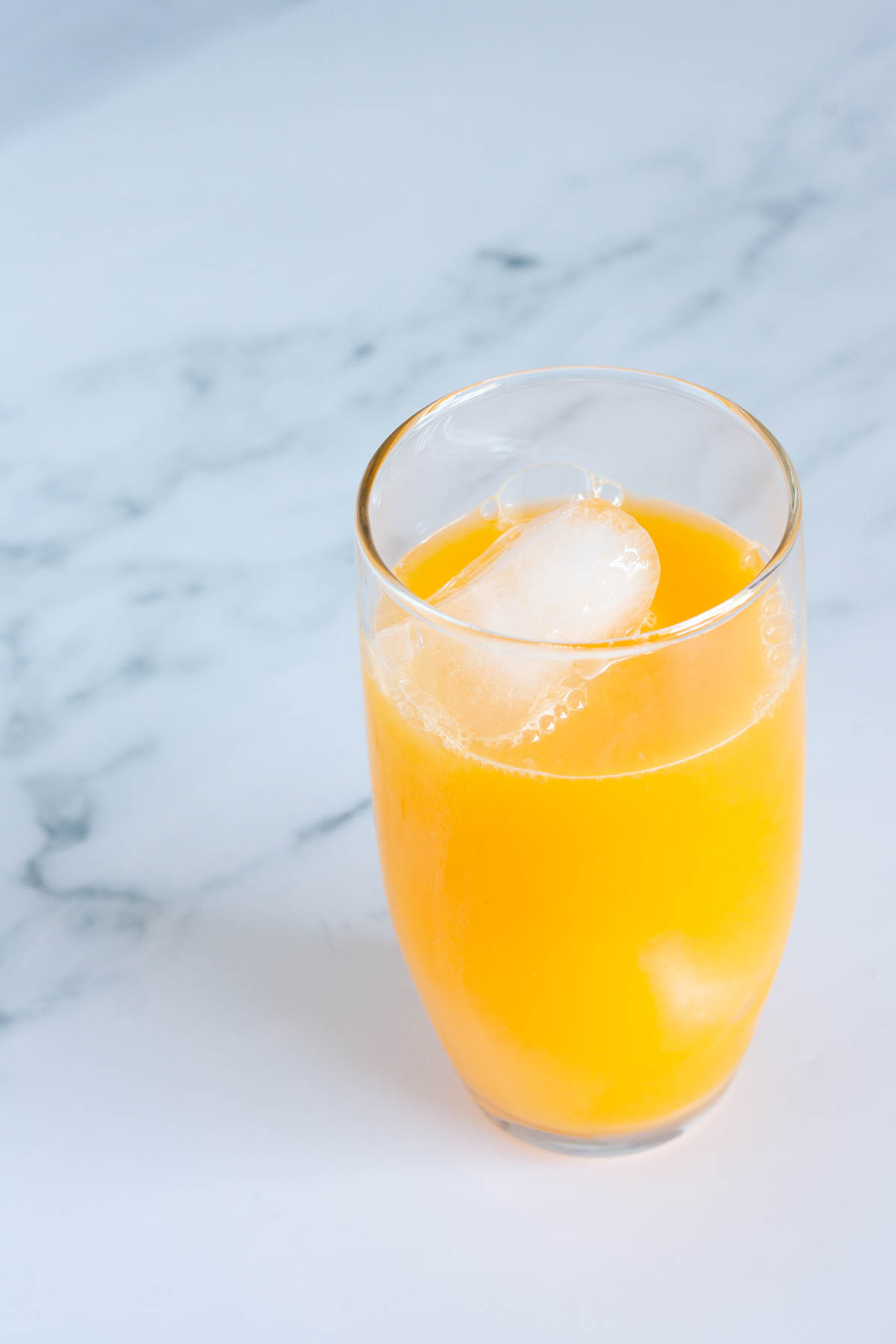 A glass filled with ice and orange juice.
