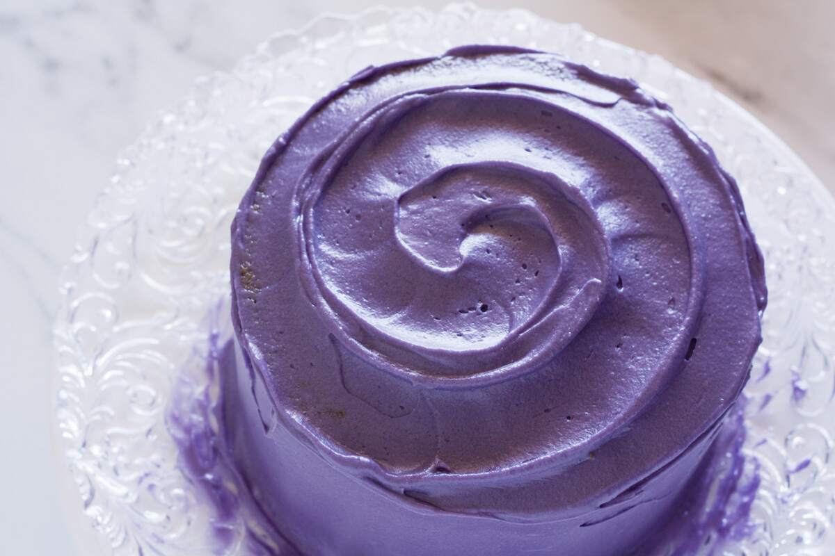 Swirled lavender-colored frosting on top of cake.