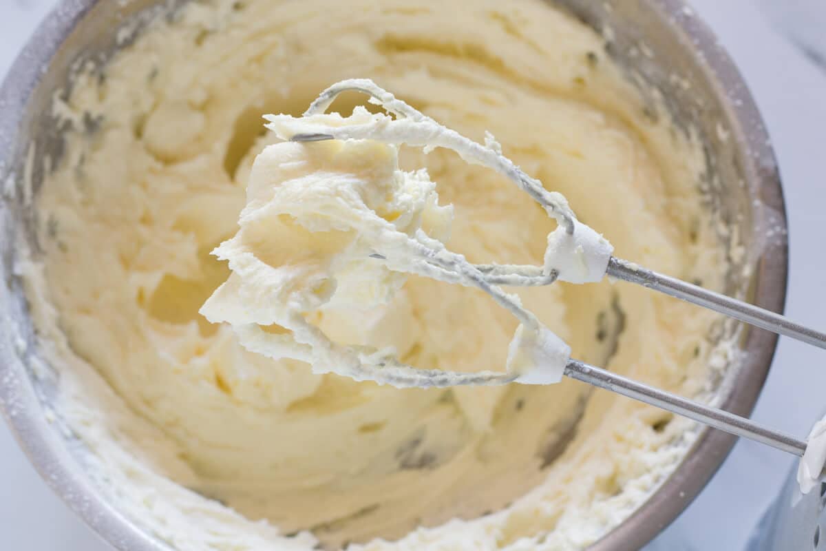 Stiff cream cheese frosting on hand mixer beaters.