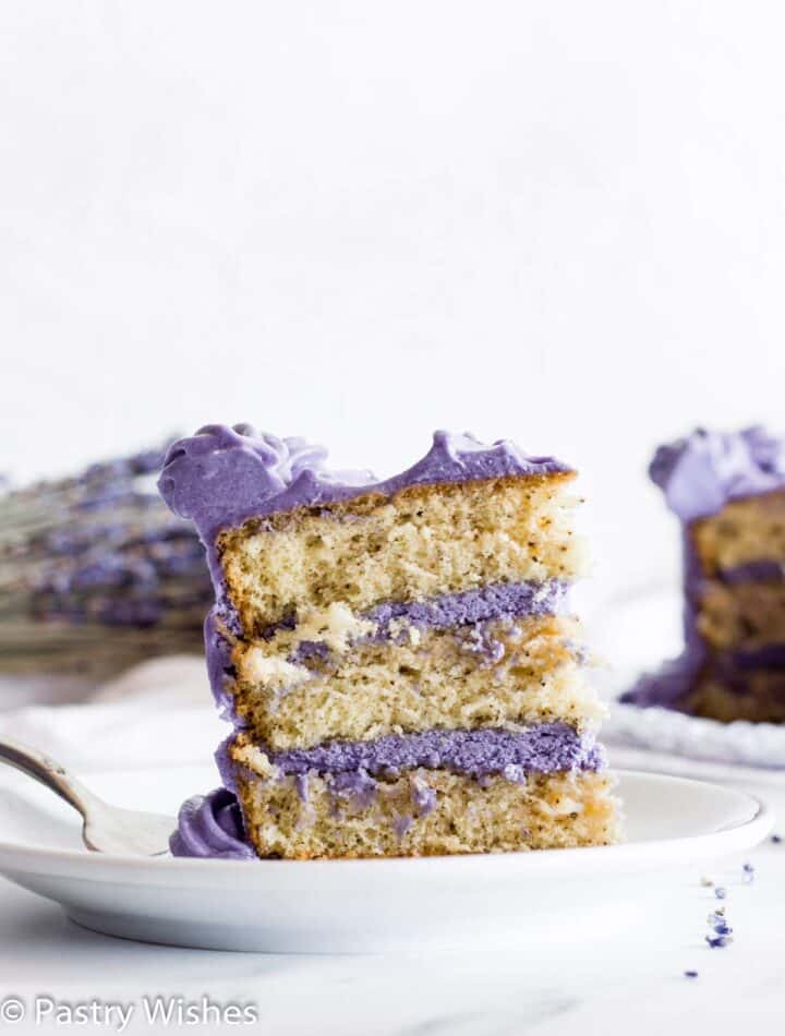 A closeup of a slice of Earl Grey lavender cake on a white plate.