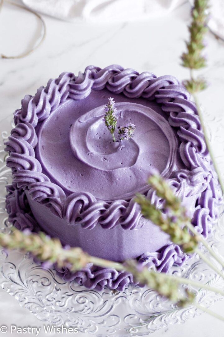 Earl Grey lavender cake on a white surface behind fresh lavender flowers.