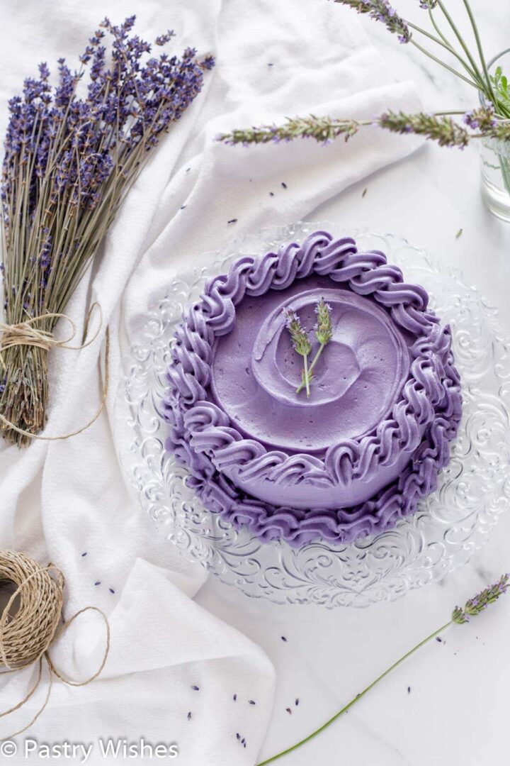 Earl Grey lavender cake on a white surface next to lavender flowers.