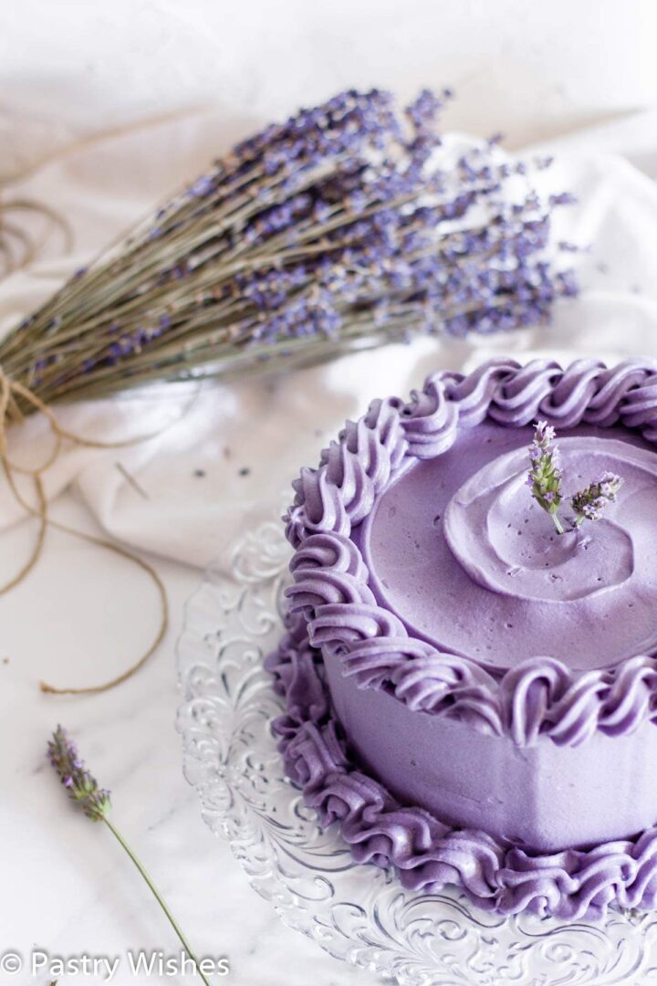 Earl Grey lavender cake on a white surface next to lavender flowers.