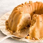 A close up of sliced Greek halva cake with a cake server on a silver platter.