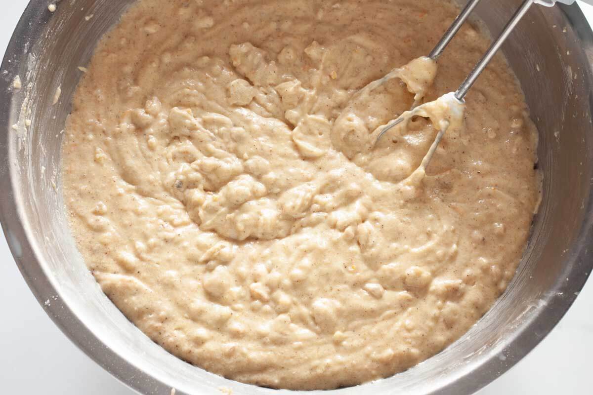 Dry ingredients mixed with wet ingredients in a metal mixing bowl.