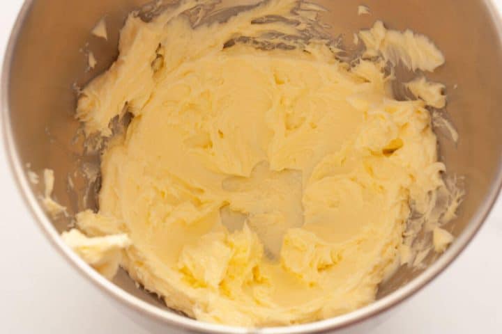 Beating butter in the bowl of a stand mixer.