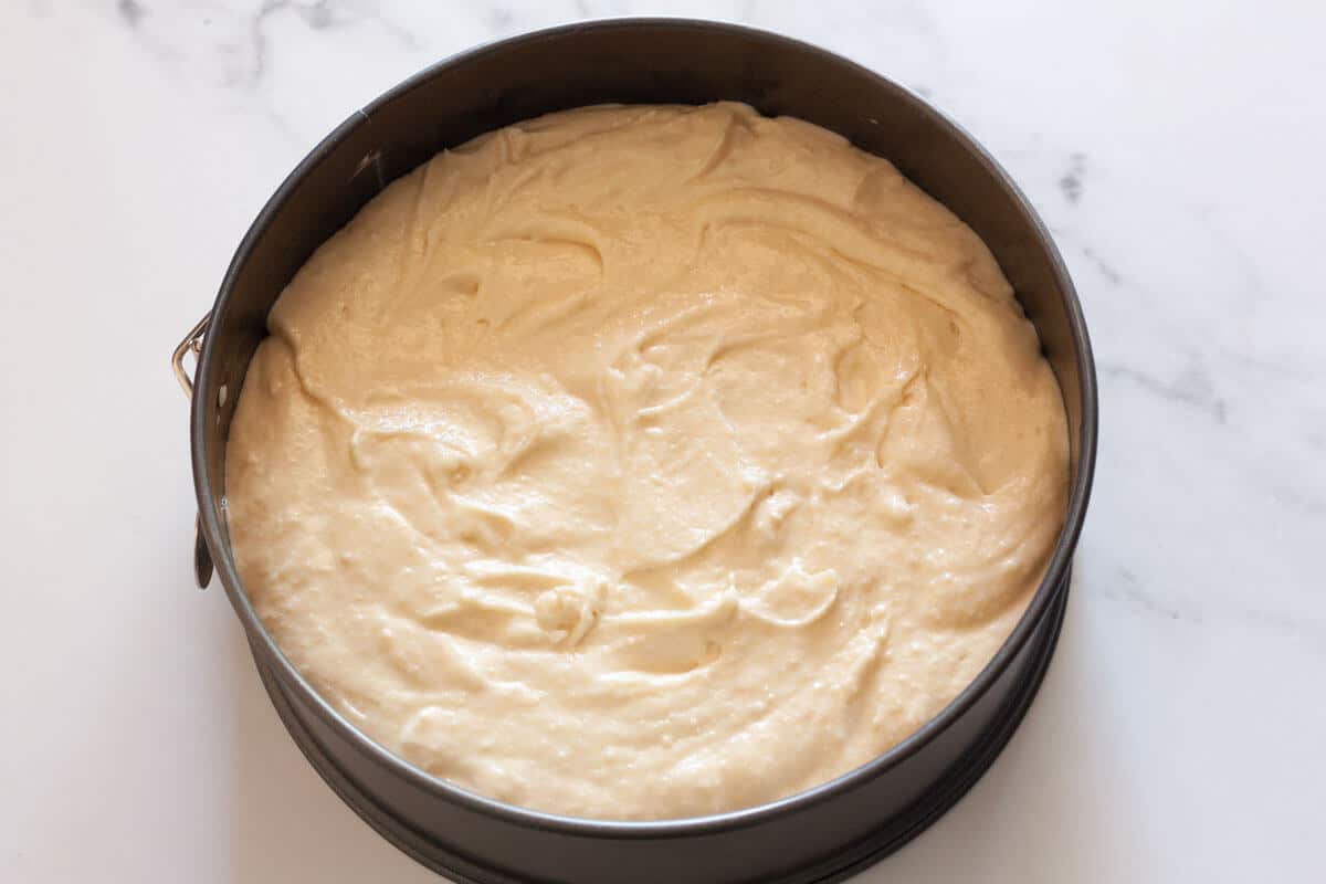 Cake batter spread in a springform baking pan.
