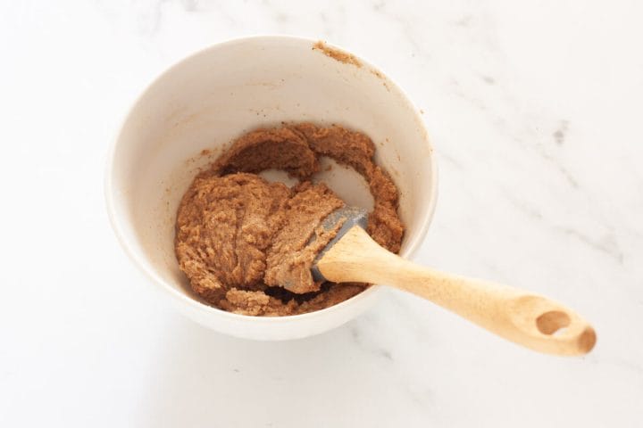 Cinnamon sugar butter in a white bowl with a spatula.