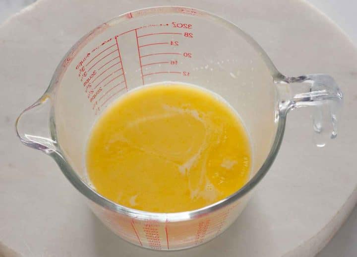 Warm milk and melted butter in a glass measuring cup.