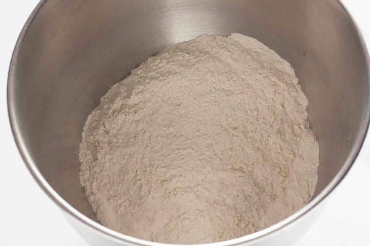 Flour, yeast, sugar and salt in a bowl of a stand mixer.